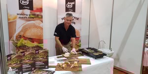 Angel Bay staff member preparing burgers for trade show
