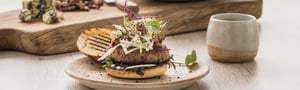 Burger with Angel Bay patty and coleslaw on plate.