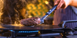 Angel Bay beef patty being cooked on hot plate.