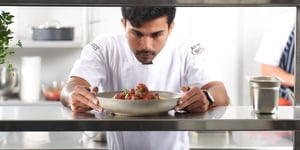 Chef plating up Angel Bay meatballs dish.