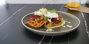 Breakfast meal on restaurant plate with poached eggs, bacon and Angel Bay veggie patty